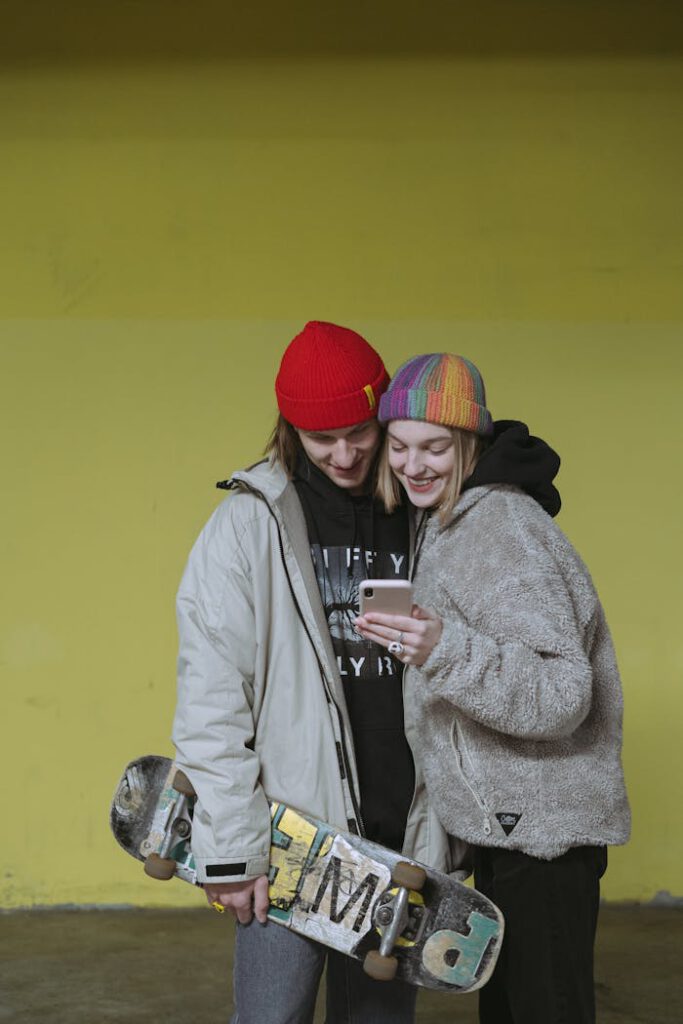 Couple Smiling while using Mobile Phone